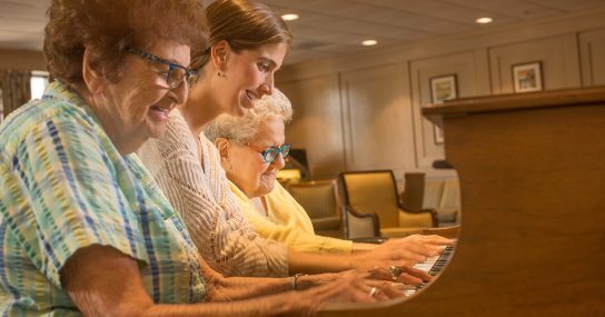 women playing the piano together