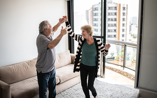 older couple dancing in their new senior living apartment